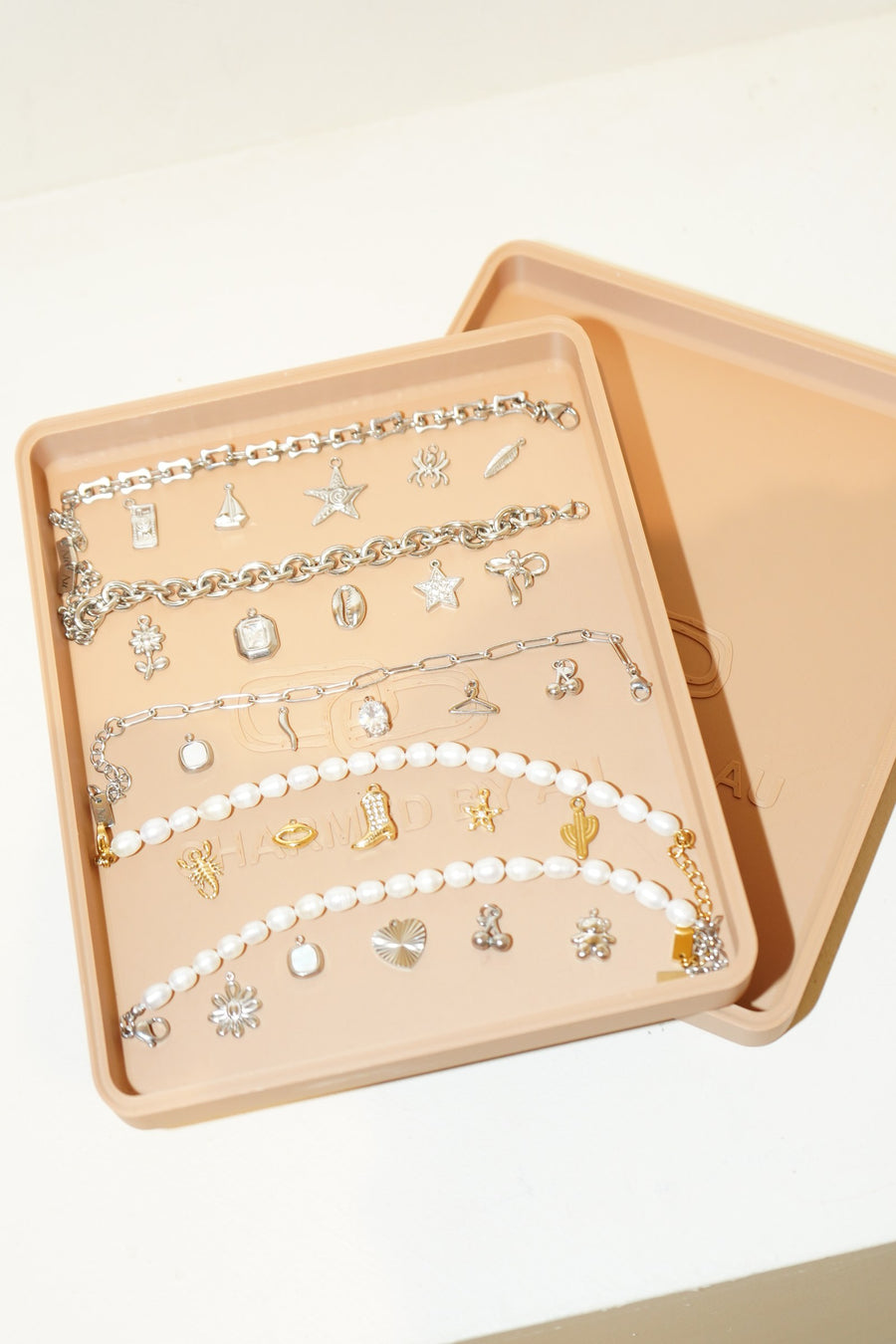Charmed by AU branded tray with bracelets and charms